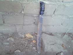 Machete recostado contra una pared de ladrillo