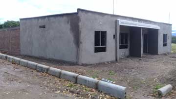 A one-floor, brick building with plastered walls still unpainted