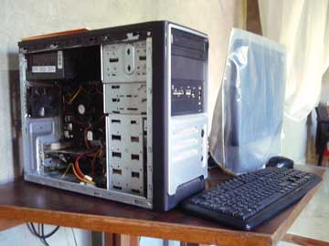 A desktop computer. The the CPU's case is open up and the screen has a plastic cover