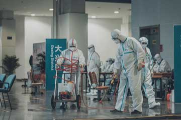 Unos hombres usando trajes protectores, haciendo fumigación dentro de un edificio