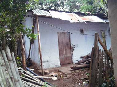 Una casa muy  pintada de blanco, la puerta sin pintar y sin ventanas