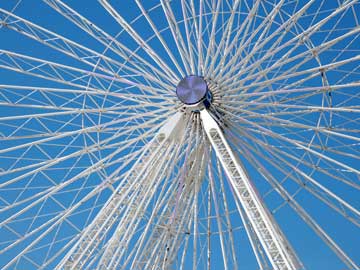 A silver Ferris wheel on a blue background