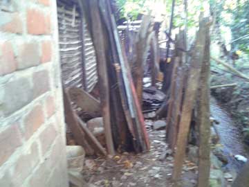 The shanty's roof dismounted. Roof tiles are stacked by the kitchen door