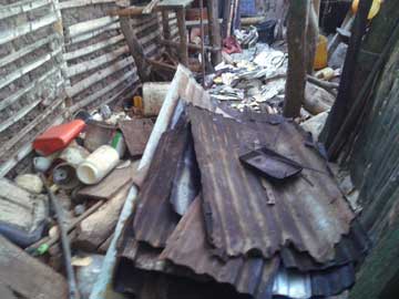 A stack of roof tiles inside the shanty's kitchen