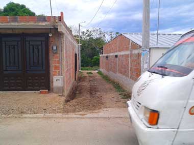 Un pasaje sin pavimentar. Un transporte público está pasando en ese momento