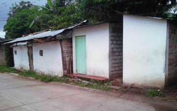 A very humble shanty with a paintless wooden door